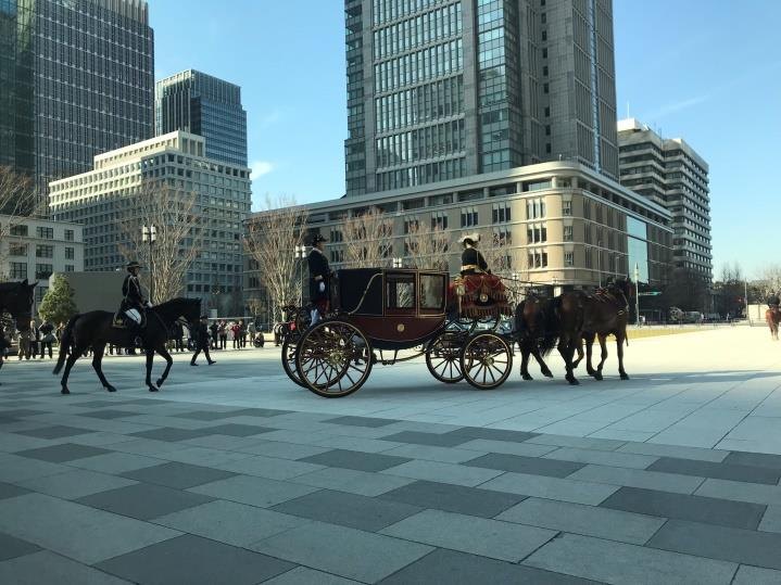 The cavalcade sets out past the towers of Marunouchi.